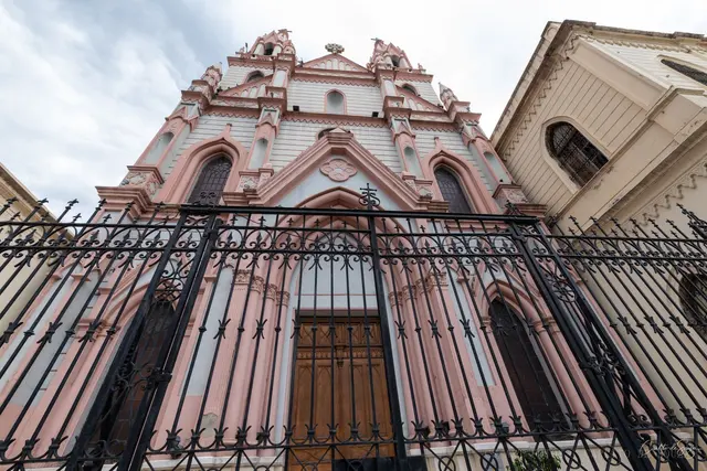 Fachada rosa atrás da grade