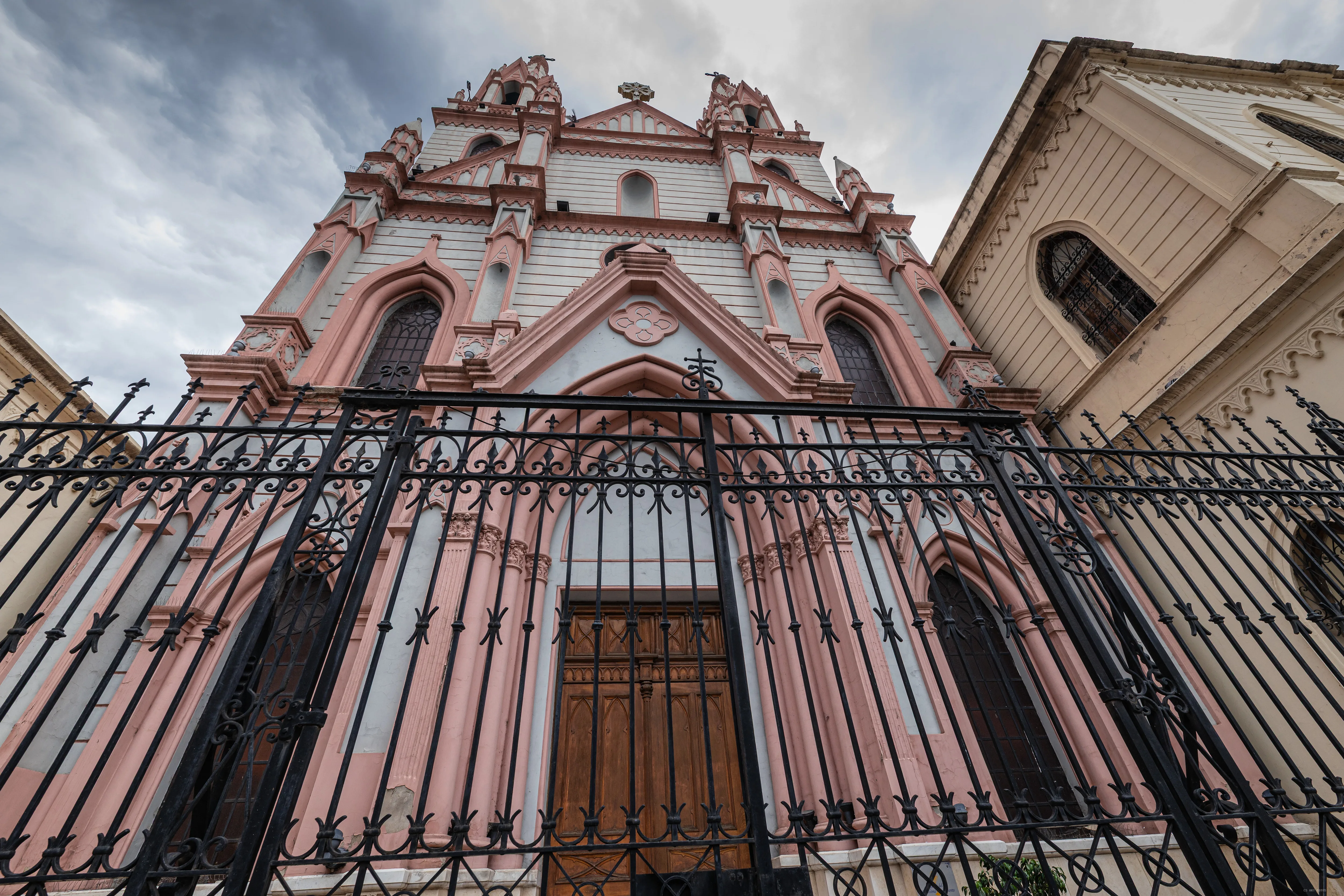 Fachada rosa atrás da grade